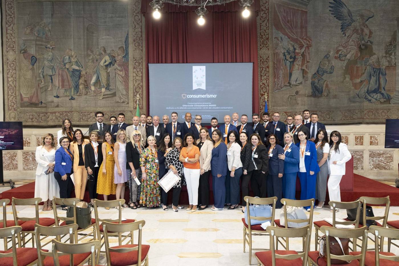 Foto di gruppo di delegati, soci, attivisti, volontari e dirigenti di Consumerismo nella Sala della Regina della Camera dei Deputati, durante l'ONorevole COnsumatore Award 2026