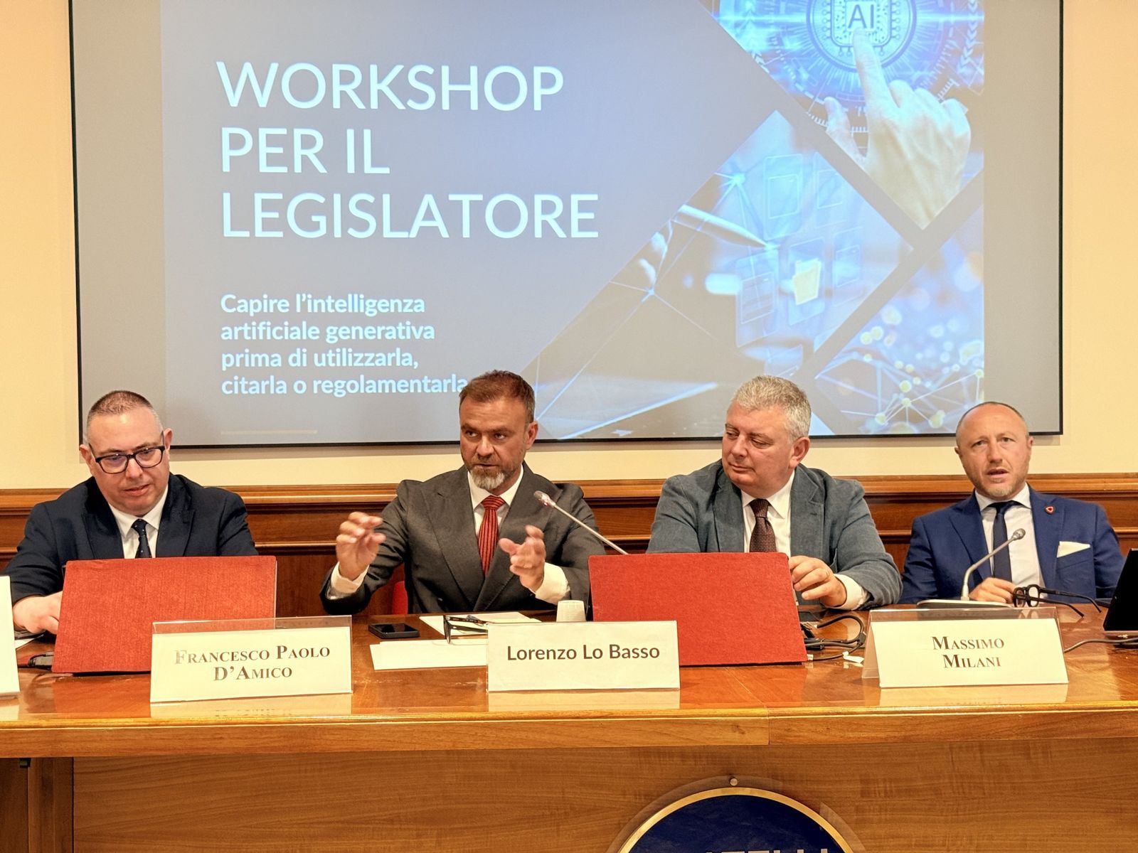 Il tavolo dei relatori del Workshop per il Legislatore alla Camera dei Deputati, con la slide del titolo sullo schermo
